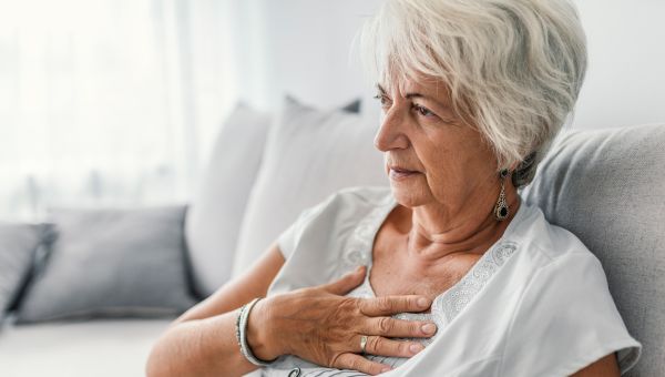 elderly woman holding chest