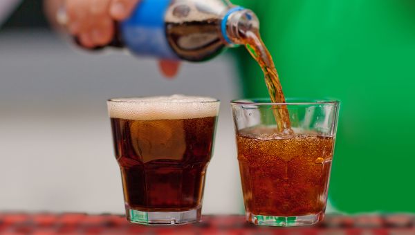 Carbonated beverages being poured into glasses.