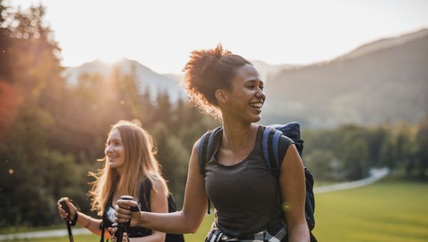 two young women go hiking on a beautiful day in nature