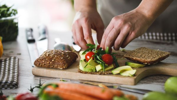 man preparing a healthy vegetable sandwich in kitchen