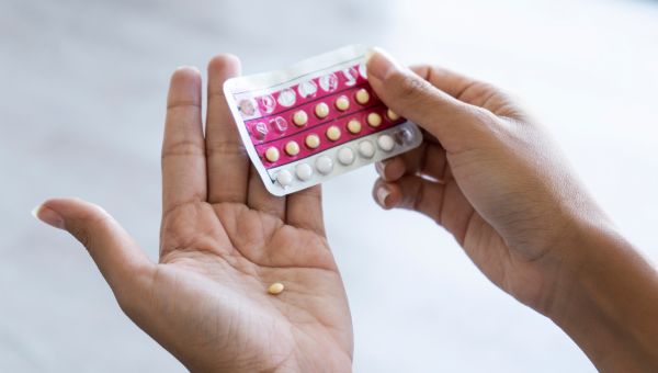 A birth control pill sitting in a hand.
