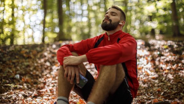 a young man relaxes in the woods after a hike