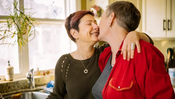 middle aged couple kissing in the kitchen
