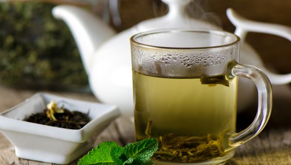 a teapot with a glass of hot green tea