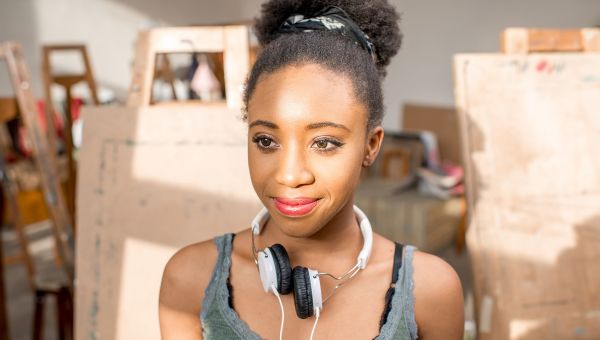 Smiling woman with headphones on basking in the sun.