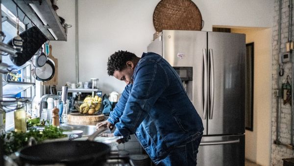 man with chronic fatigue at kitchen counter