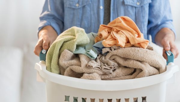 Person holds a basket of laundry.