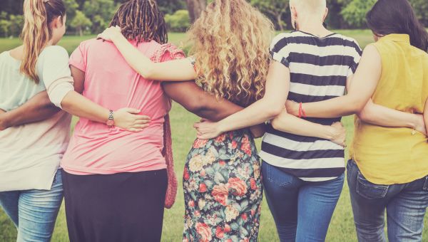 Group of people with their arms around each other.