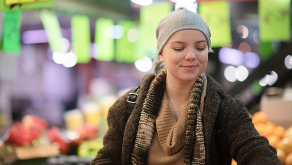 Woman with cancer carrying her groceries into her kitchen