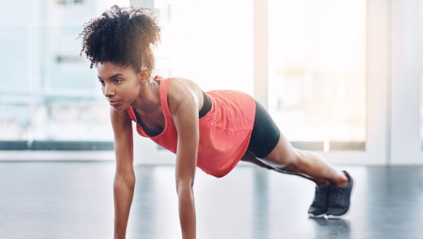 a Black woman does pushups for exercise