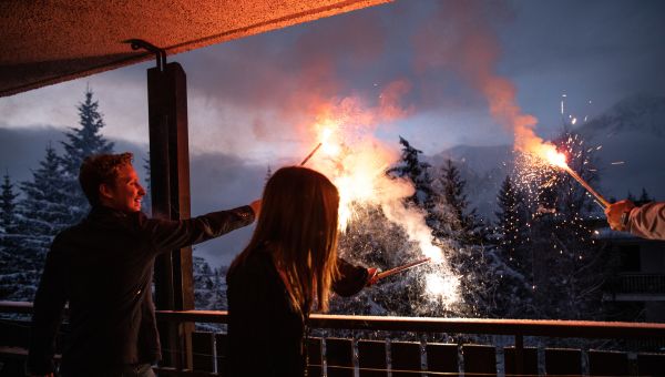 group of friends on a balcony holding sparklers