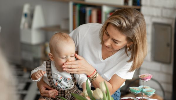 blonde mom supports her coughing baby