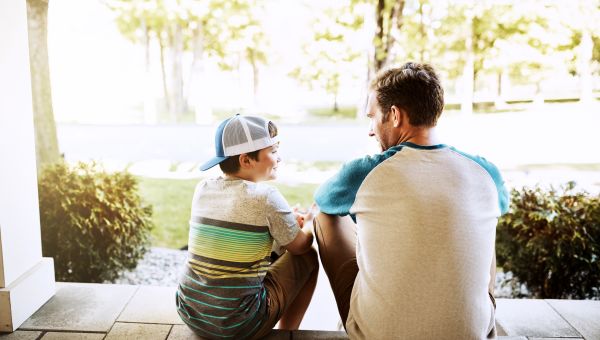 father and son sitting outdoors