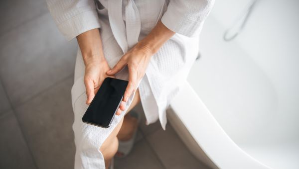 woman holding phone in robe