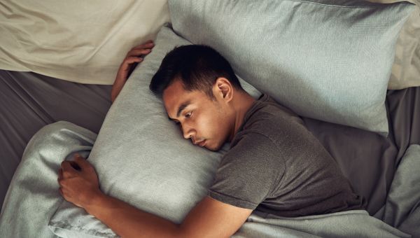 stressed man in bed trouble sleeping