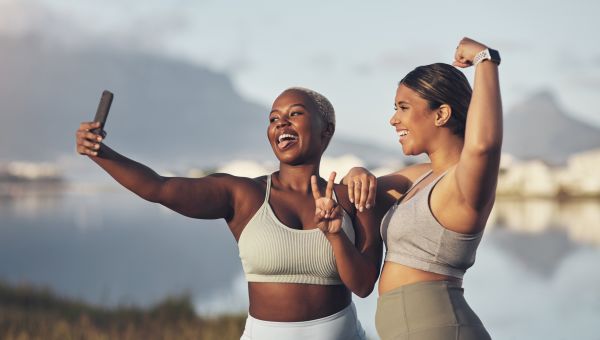 two fit Black woman take a selfie after exercising