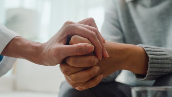 one hand holding and consoling another pair of hands