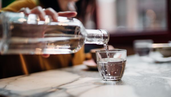 woman pouring water on table