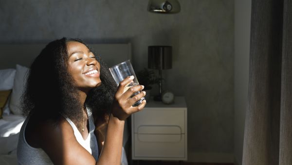 black woman with great skin drinking water