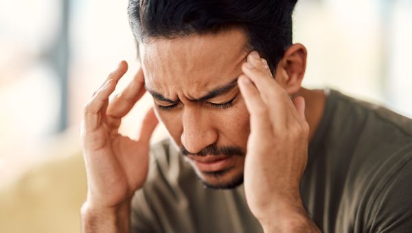 young man with headache and hands at temples