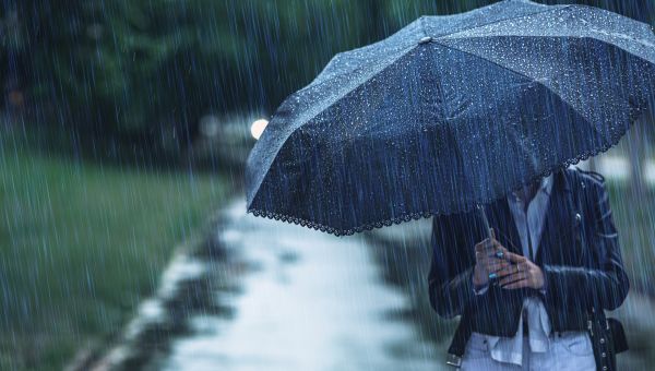 adult women walking in rain with an umbrella 