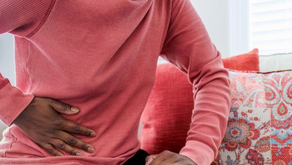 closeup of someone with hand on right side of lower abdomen