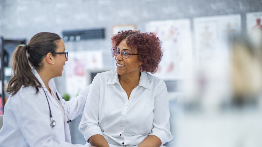 Middle-aged black women in office with young female doctor