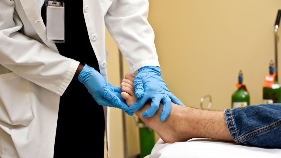 Doctor examining a male patient's foot