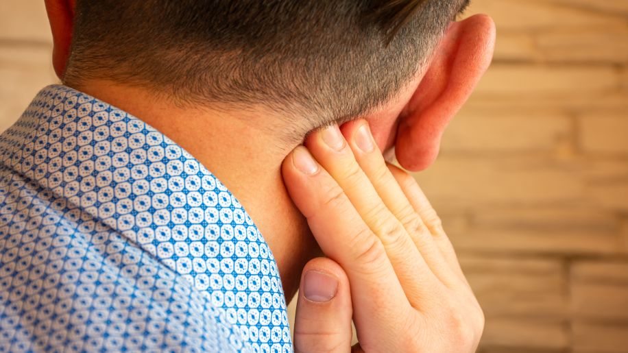 man checking for moles behind his ear