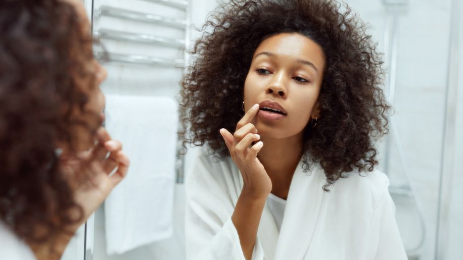 Woman checking her lips in the mirror