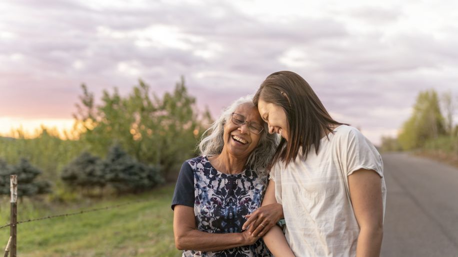 Happy mother and daughter walking and talking outside