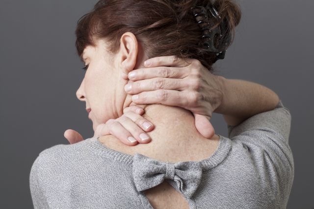 woman rubbing back of her neck