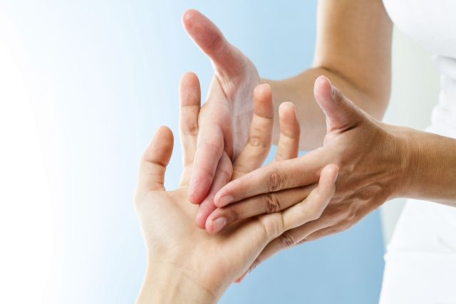 Detail of hands massaging hand.