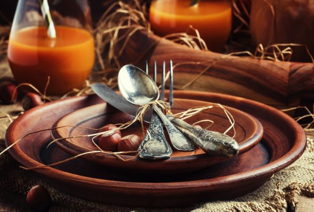Rustic table setting for Thanksgiving Day: pottery, vintage appliances, straw, nuts and pumpkin. Old wooden background, selective yfokus