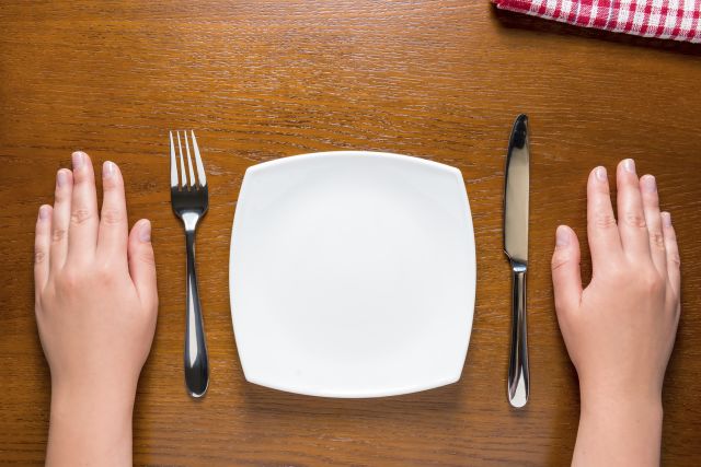 female hands near empty plate on the table