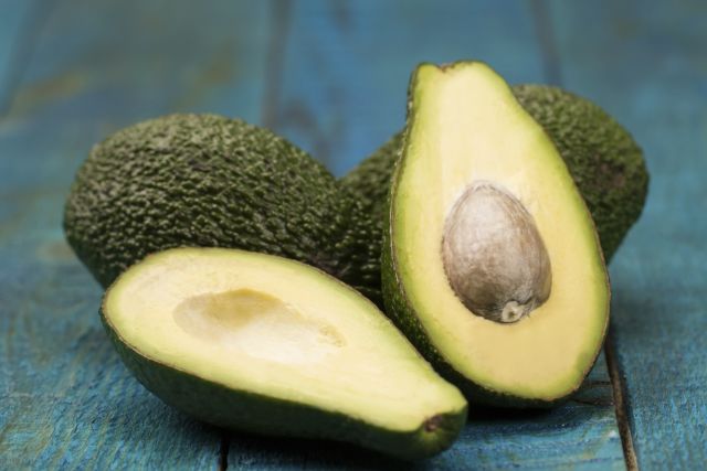 fresh avocados on wooden background. Healthy food, diet. Vegetarian.