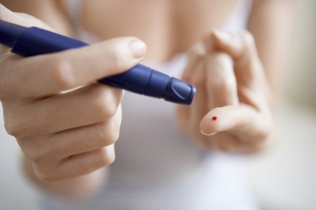 Woman Performing Blood Test on Herself