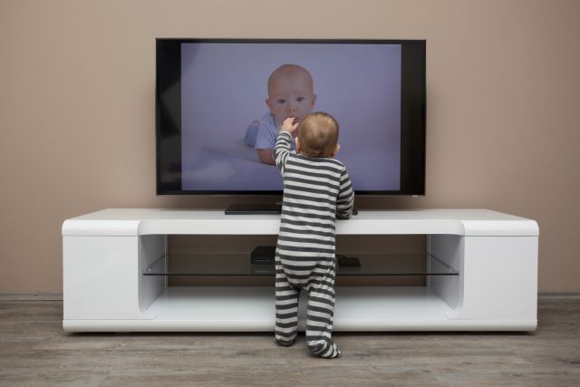 toddler grabbing for tv on stand