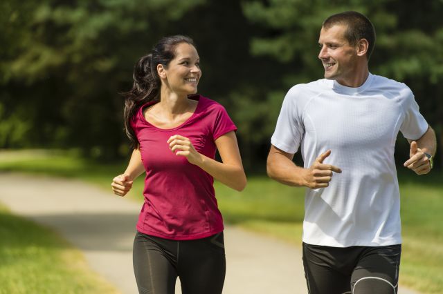 Two cheerful people running outdoors