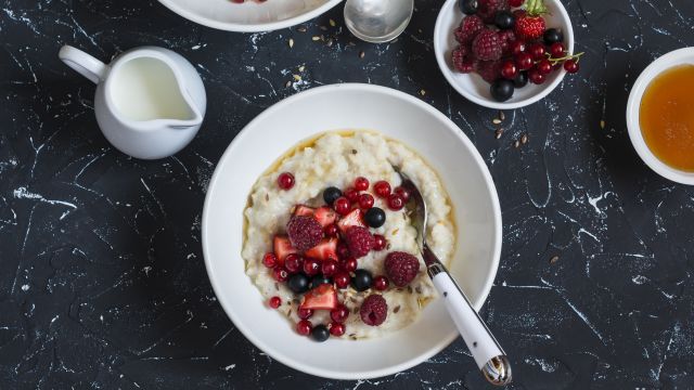 Oatmeal with berries and honey on a dark background 