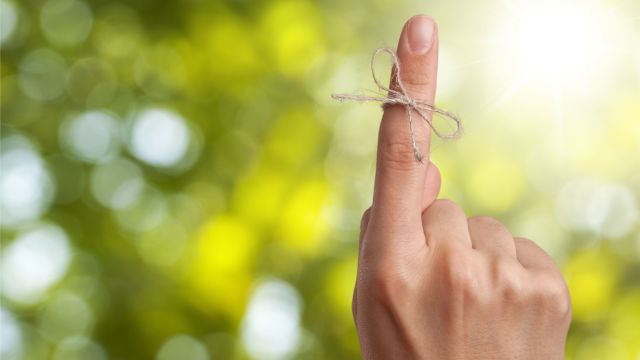 Reminder ribbon tied around person's pointer finger