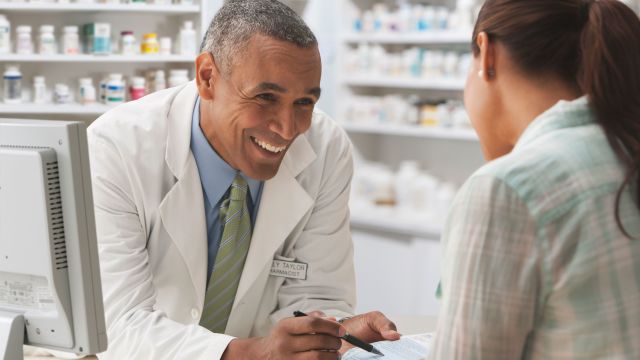 Pharmacist giving medication instructions to woman