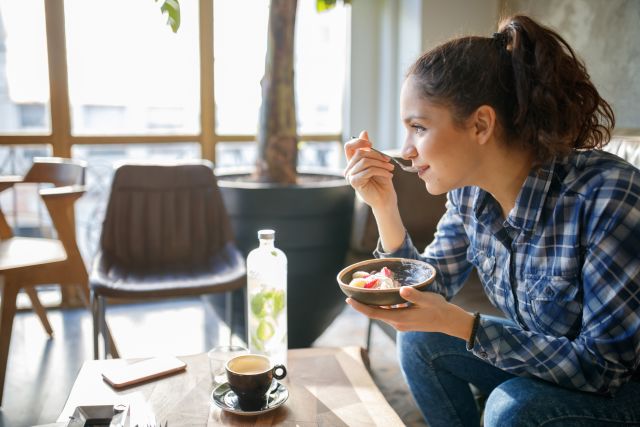young woman eating healthy food indoors