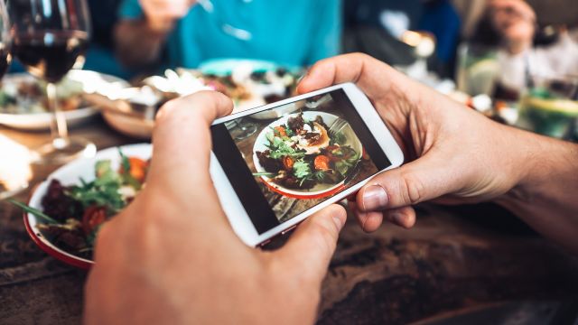 A man uses a food tracker app to take a photo of his dinner. He knows meal trackers help keep his diet on track.