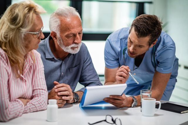 A bladder cancer patient and caregiver consult with a member of their healthcare team.