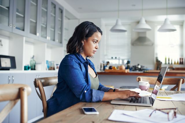 Woman at computer with paperwork