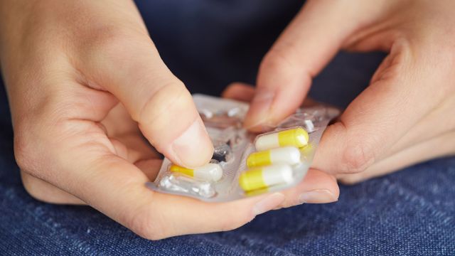 hands opening a pill pack