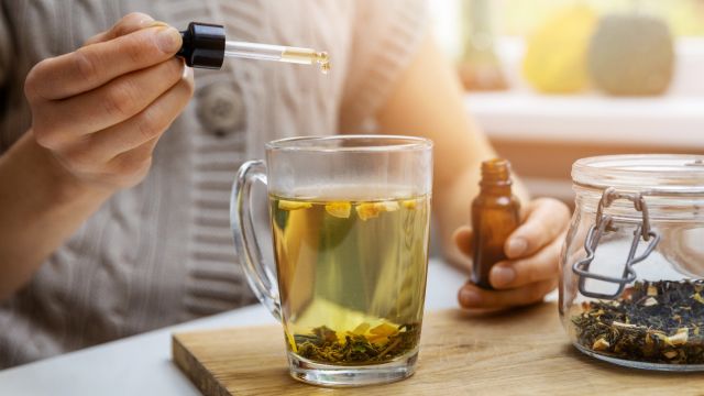 woman putting cbd oil in team