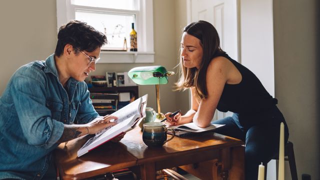 Couple looking through a book in the comforts of their own home.