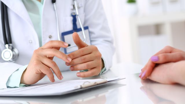 Doctor with a clipboard talking to a patient.